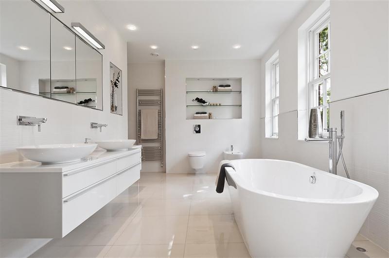 Witte badkamer met dubbele opzetwastafel, vrijstaand bad, toilet