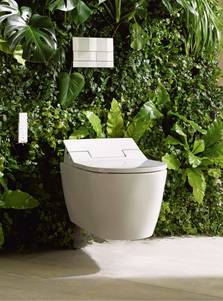 een toilet met een toiletbril met een muur van planten